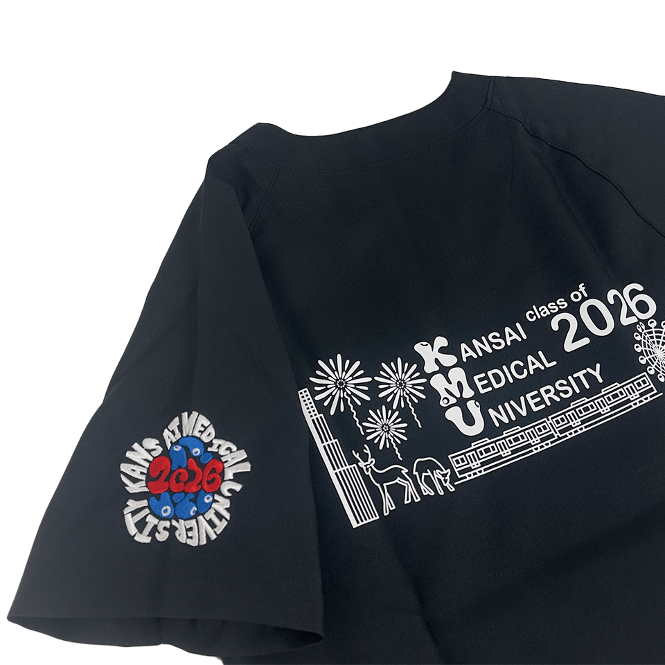 中央に赤い数字「2026」と青い目の模様が絡み合ったデザインがあり、その周囲を「KANSAI MEDICAL UNIVERSITY」の白い文字が囲んでいる。
