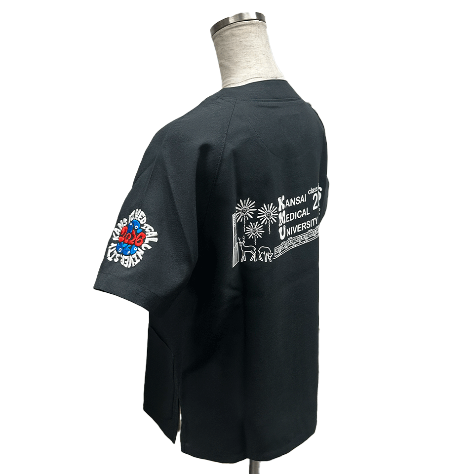 中央に赤い数字「2026」と青い目の模様が絡み合ったデザインがあり、その周囲を「KANSAI MEDICAL UNIVERSITY」の白い文字が囲んでいる。