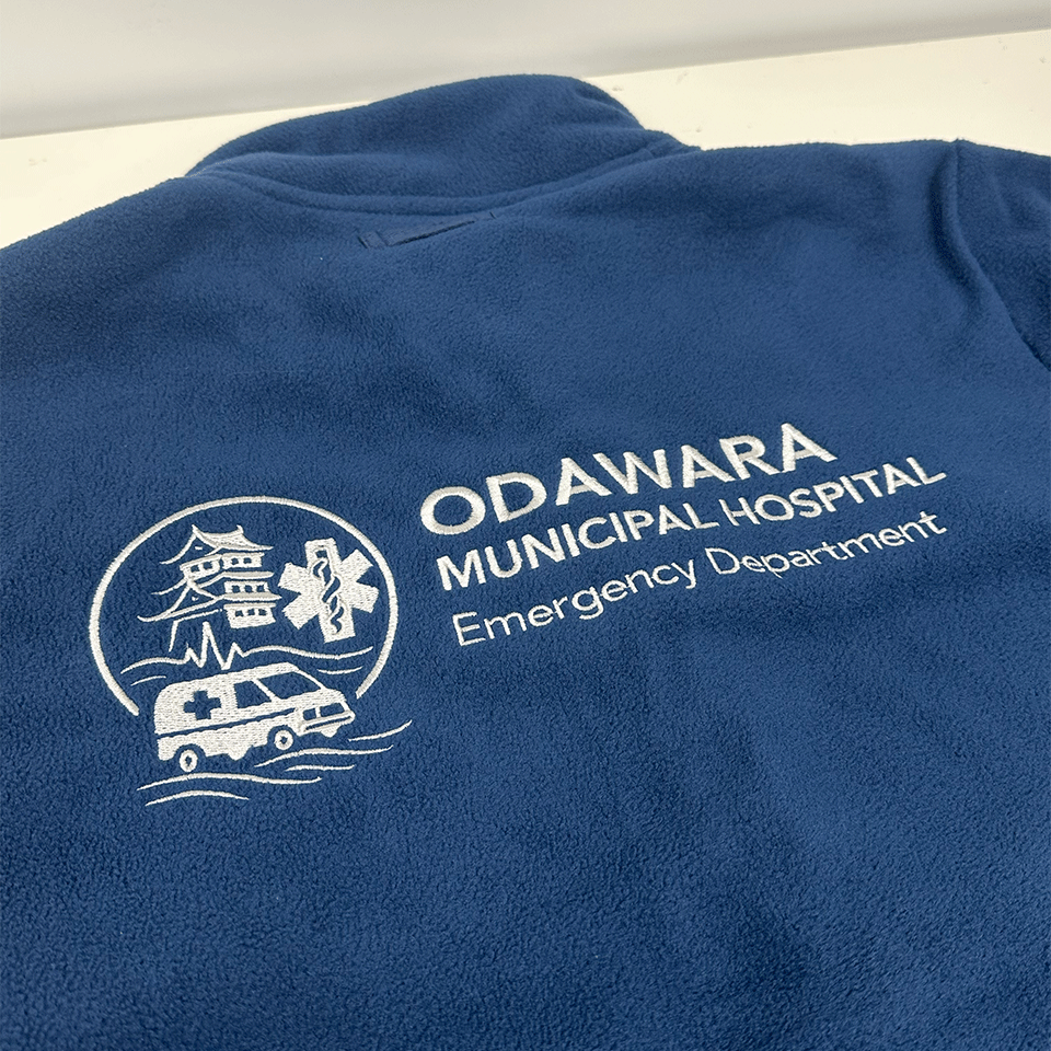 小田原市立病院救急科のロゴ刺繍。左側に小田原城と救急車のエンブレム。