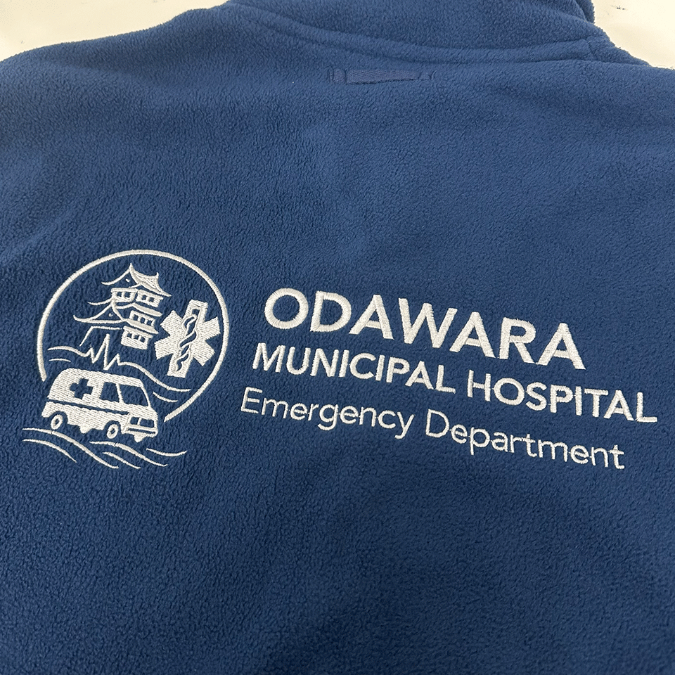 小田原市立病院救急科のロゴ刺繍。左側に小田原城と救急車のエンブレム。