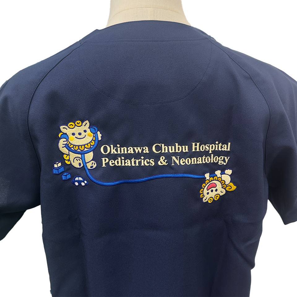 沖縄県立中部病院小児科様のオリジナル刺繍。ネイビーの生地に、シーサーと聴診器、英字ロゴが施されています。