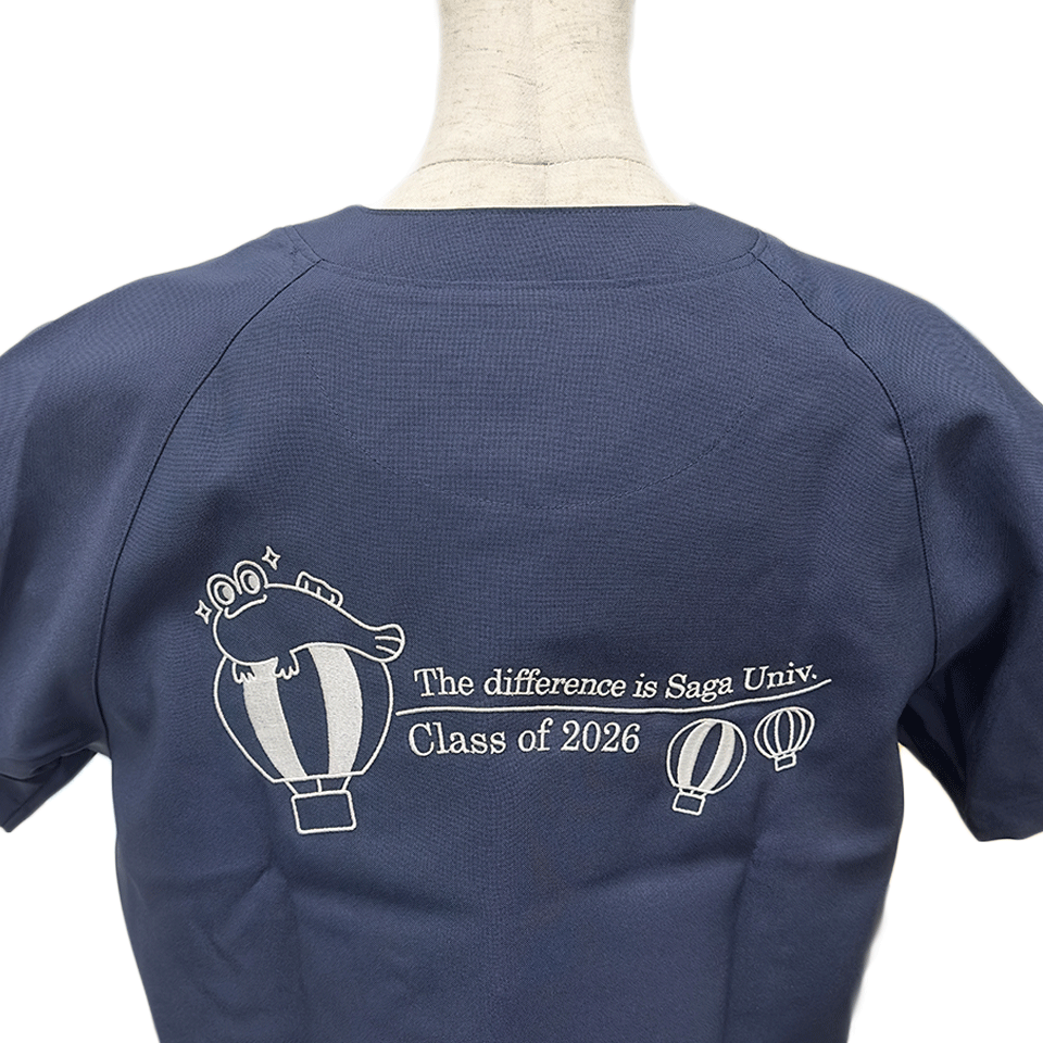 佐賀大学医学部様の刺繍正面デザイン。バルーンにしがみつくムツゴロウの表情やロゴなど、精緻な仕上がりを詳細に示しています。