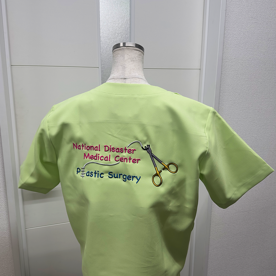 形成外科の専門性を表現した精緻な刺繍デザイン。持針器のゴールド部分や繊細な縫合糸のラインを多色刺繍で再現