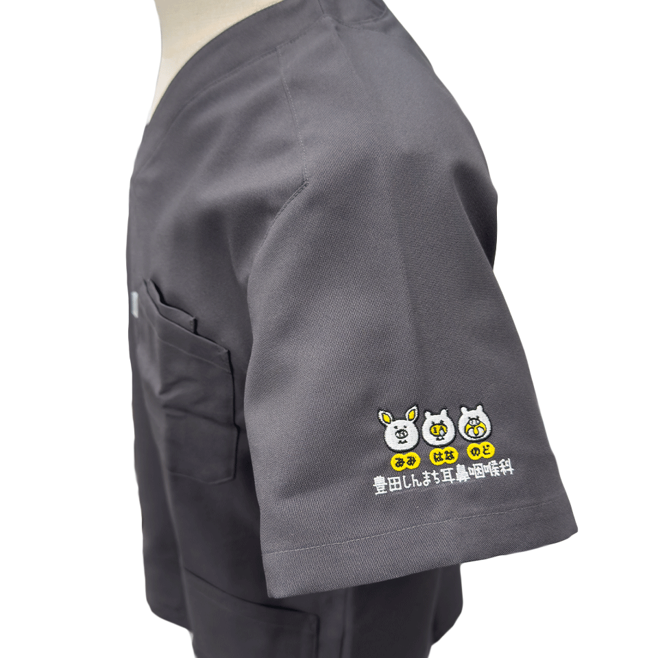 スクラブの袖に施された立体感のあるロゴ刺繍。