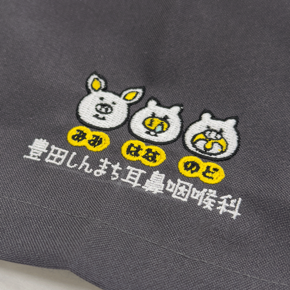 スクラブの袖に施された立体感のあるロゴ刺繍。